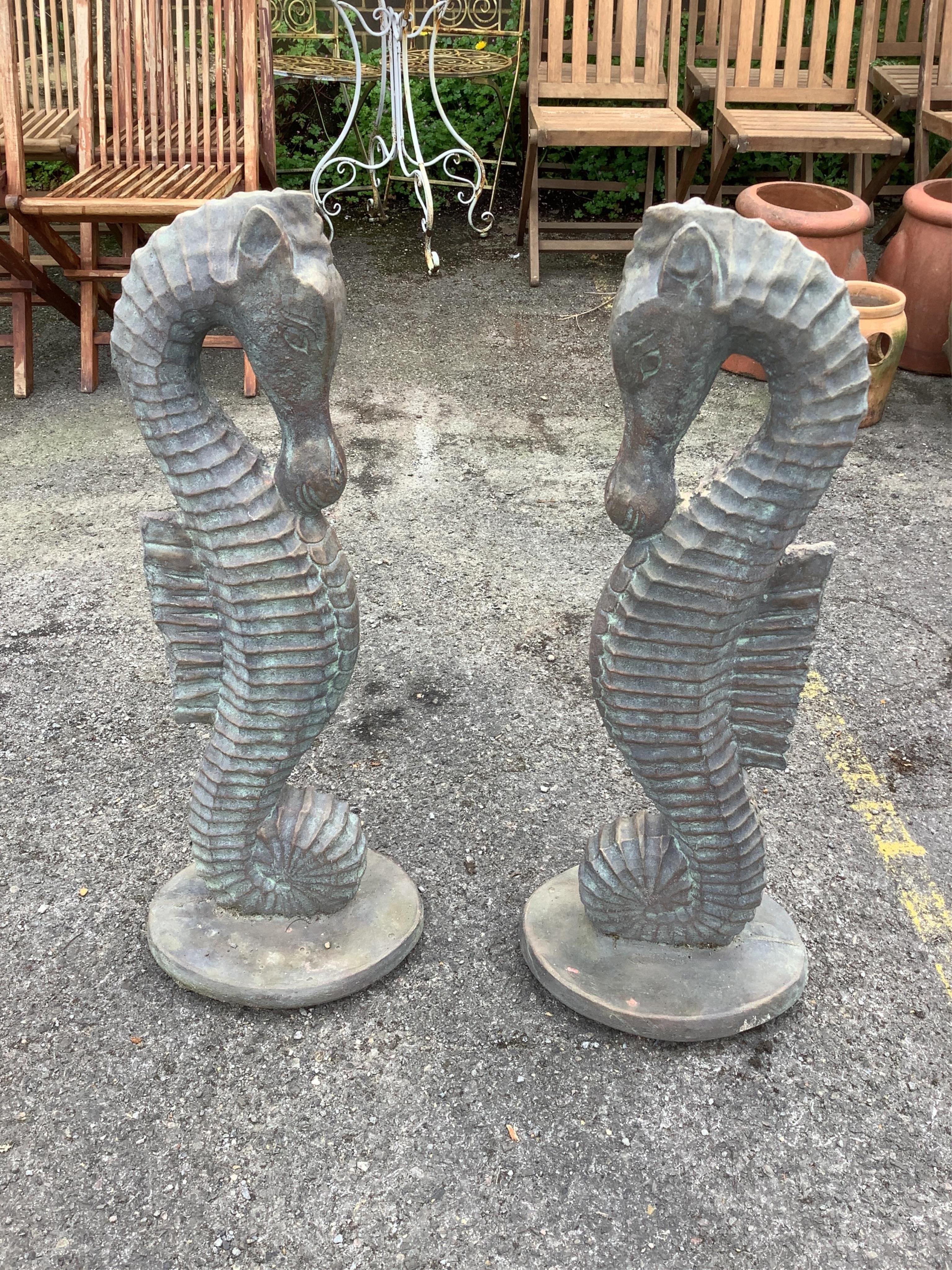 A pair of faux bronze cast stone seahorse garden ornaments, height 82cm